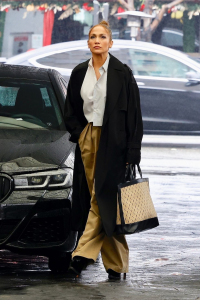 Jennifer Lopez Wears a Black Trench Coat and Trousers on a Rainy Day