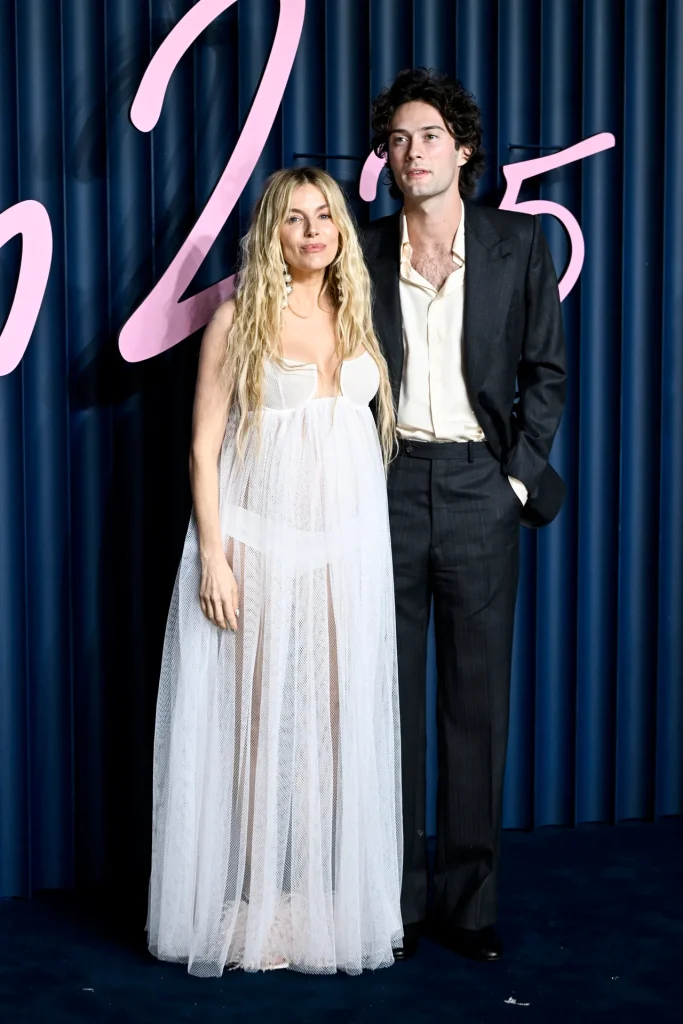 Sienna Miller has been keeping a low profile of late, and now, we know why. The actor is expecting her third child (her second with the actor Oli Green), and she was seemingly waiting for the Fashion Awards to reveal her news.
Read more: Every Major Red-Carpet Look At The Fashion Awards 2025
Play/Pause Button
It’s a fab personal PR move (is there anything more joyous than a baby bump on a red carpet?) that we’ve seen before. At Vogue World: London in 2023, a pregnant Miller walked the red carpet in a Schiaparelli puffball skirt and a ruched, cropped shirt that swiftly became the standout look of the night. “Her choice is our honour,” said Schiaparelli creative director Daniel Roseberry, while her stylist at the time, Harry Lambert, enthused: “It deserves to make headlines!” The directional cloud-like two-piece sure did.
Image may contain Sienna Miller Adult Person Wedding Fashion Photobombing Blazer Clothing Coat and Jacket